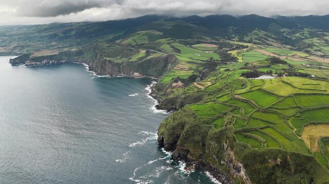 Patchwork green fields along rocky Atlantic coast on Sao Miguel Island, Azores. Aerial view