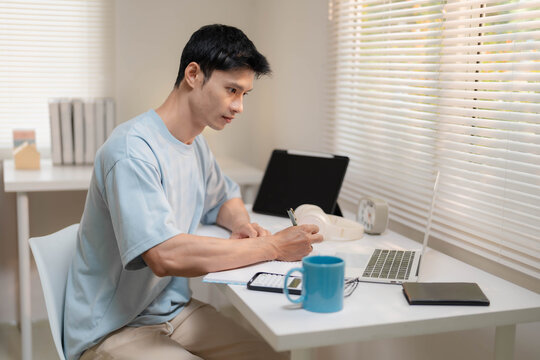Young Asian Freelancer Working from Home and Calculating Personal Finances