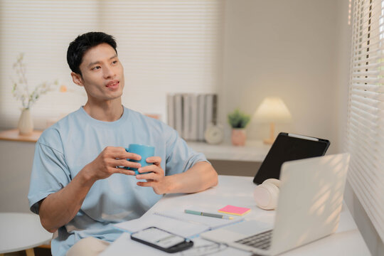 Young Asian Freelancer Working from Home and Calculating Personal Finances
