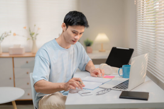 Young Asian Freelancer Working from Home and Calculating Personal Finances