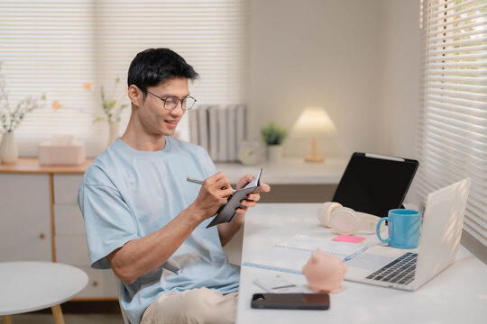 Young Asian Freelancer Working from Home and Calculating Personal Finances