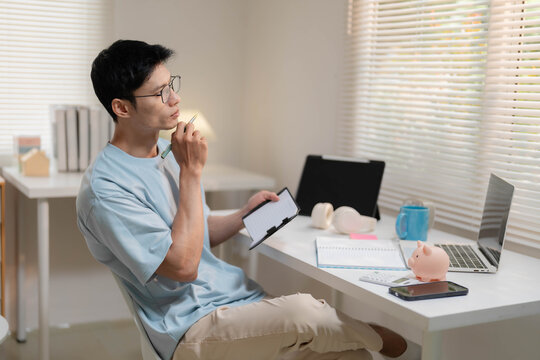 Young Asian Freelancer Working from Home and Calculating Personal Finances