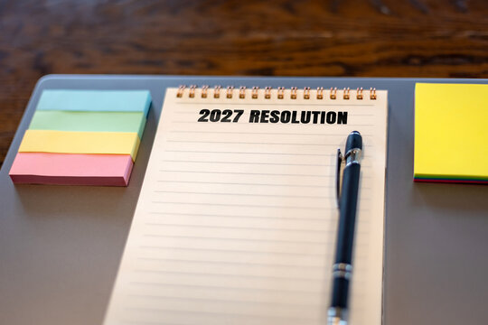 Blank 2027 Resolution notebook page with pen and colorful sticky notes on desk, empty checklist template