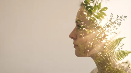 Double exposure portrait of a young woman profile combined with green forest leaves and ferns on a warm background © Imam