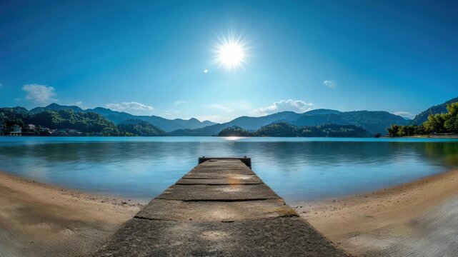 Wooden Pier Reaching into a Calm Lake and Mountain Landscape Under Sunny Sky