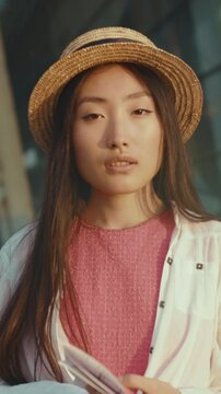 Student notes during sunset, Urban scene featuring thoughtful Asian woman with notebook during golden hour