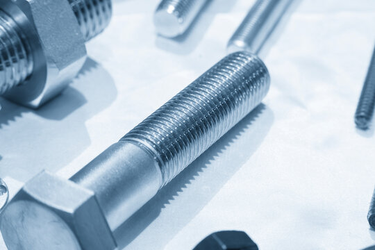 Macro close up of screw thread on steel construction bolt in dramatic blue tone lighting