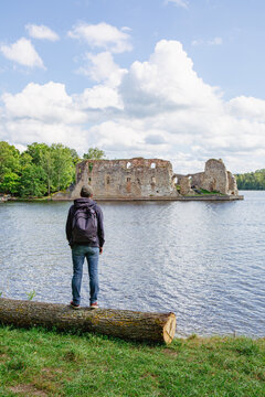 Man is standing and looking to the Koknese castle ruins at the river Daugava in August in Koknese in Latvia
