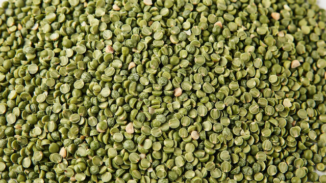 A top-down, close-up photograph of a dense pile of green split peas