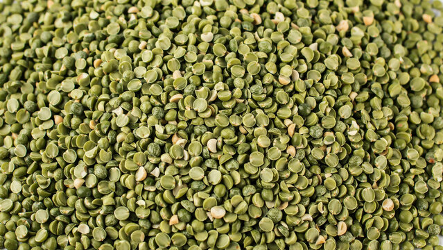 A top-down, close-up photograph of a dense pile of green split peas