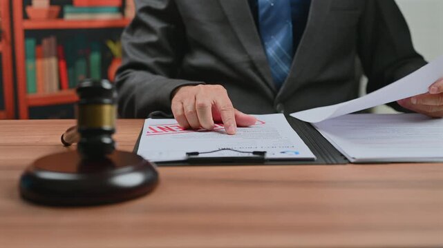 Lawyer reviews confidential files in court, as corporate lawyer prepares legal arguments upcoming court hearing while another lawyer discusses justice system inside office.