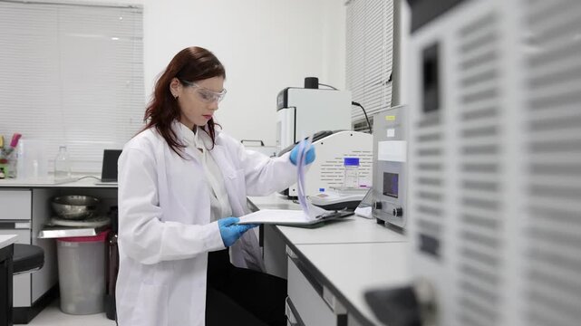 Stressed scientist analyzing research data in a laboratory. Female laboratory technician feeling worried while reading a scientific report. Anxious researcher reviewing experiment results in a lab.