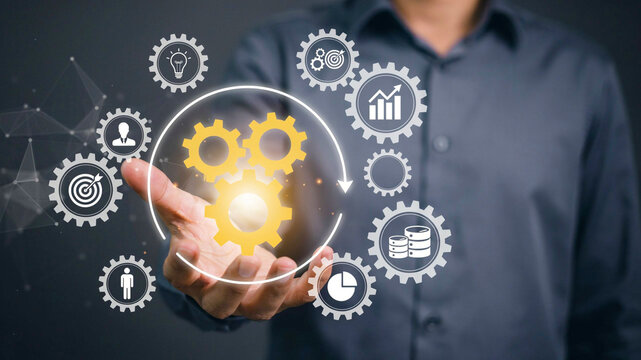 Futuristic Digital Business Process Management Concept with Glowing Holographic Gears and Analytics Icons in Man's Hand