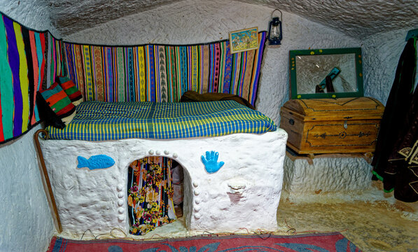 Interior View of Traditional Troglodyte Bedroom with Textured White Cave Walls and Folk Decor