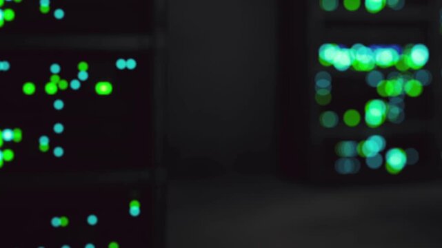 A data center is shown with rows of servers in the background. Colorful lights indicate network activity throughout the facility during nighttime.