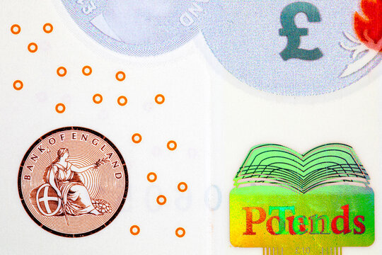 British 10 ten pounds polymer banknote, showing the Bank of England seal featuring Britannia, a holographic book emblem with word-changing foil, and security print elements, representing UK currency
