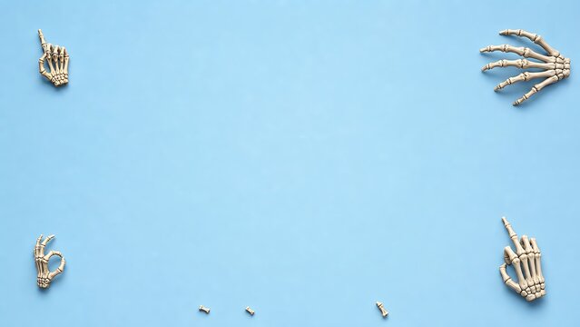 Top view of human hand skeleton models arranged as a frame on a solid light blue background with copy space