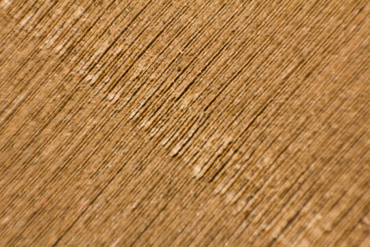Close-up macro photography of textured wooden surface with diagonal grain lines and natural brown timber patterns