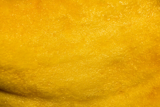 Close-up macro texture of ripe yellow fruit skin with natural organic surface details