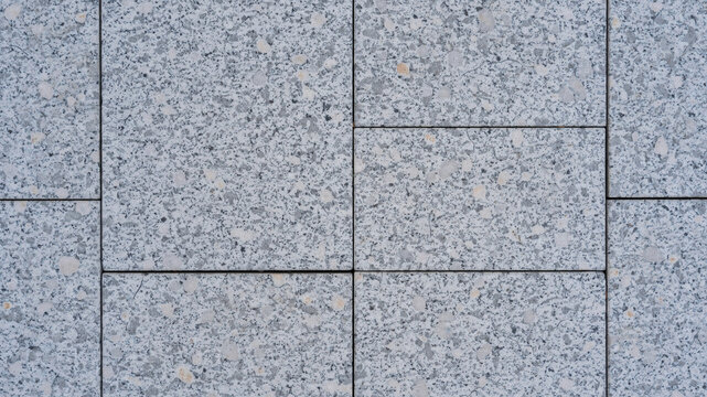 Grey granite stone paving texture. Top view of outdoor floor tiles with seamless pattern.
