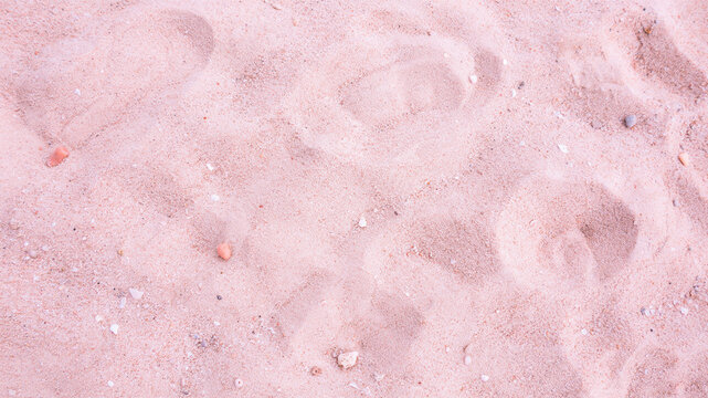 Aerial view of pink sand beach. Top down drone shot of soft pastel tropical shoreline.