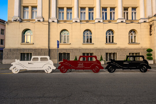 Banja Luka, Bosnia and Herzegovina - August 12, 2026: Creative vintage car-shaped bicycle stands installed in front of the City Administration building (Gradska uprava) in Banja Luka, Bosnia and Herze