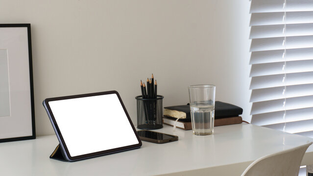 Blank tablet screen displayed on a clean modern workspace desk.