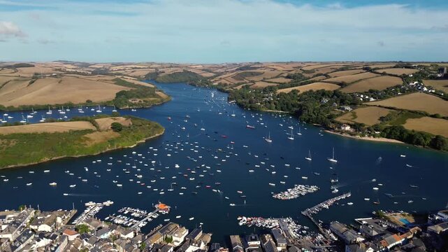 Aerial drone view of Salcombe harbour filled with boats on a sunny summer evening