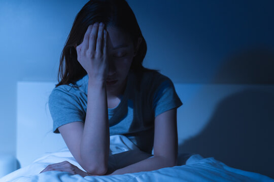 Sad worried and stressed, depressed asian young woman, girl suffering in bed from insomnia problem, awake at night, hand covering face from trouble disturbed loud noise, unable sleep. Restless people.