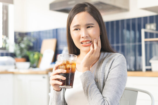 Health care asian young woman touching mouth, expression, girl suffering from toothache, decay or sensitivity cavity molar tooth or inflammation drink cold, sparkling water. Sensitive teeth people.