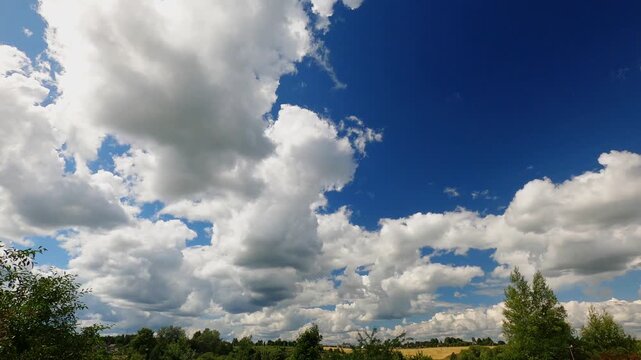 Bright Sunlit Summer Clouds Traveling Across Clear Blue Sky Above Distant Horizon, Cloud Movement Timelapse