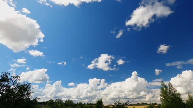 White Puffy Clouds Drifting Through Sunny Summer Sky Above Open Landscape Horizon, Blue Sky Timelapse