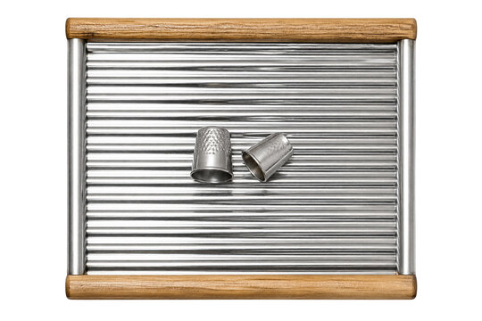 Textured metal washboard with wooden ends holding thimble isolated on transparent background PNG element
