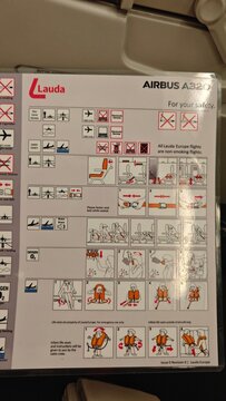 Vienna, Austria - April 02, 2026: Lauda Airbus A320 safety instruction card displaying emergency procedures and regulations for passengers in an aircraft cabin setting