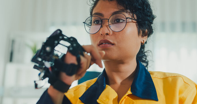 Close-up young Black female engineer coding AI robot arm in modern laboratory. Robotics, artificial intelligence, technology, stem, future, innovation, diversity, automation, machine learning concept.