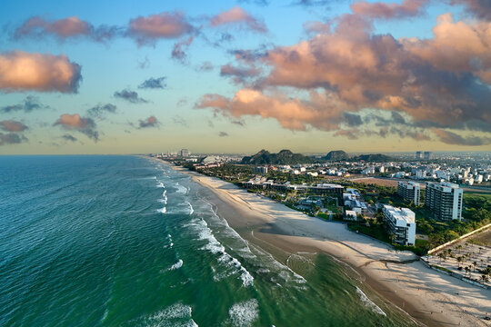 Luxury hotels line the coast of Da Nang in Vietnam while gentle waves wash over the sandy beach under a bright blue sky on a summer afternoon