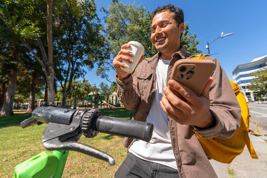 busy lifestyle man using electric scooter in city sidewalk cell phone