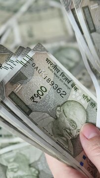 Woman's hands counting Indian 500 rupee banknotes (INR). Close-up view of Indian cash money. Vertical slow motion video.