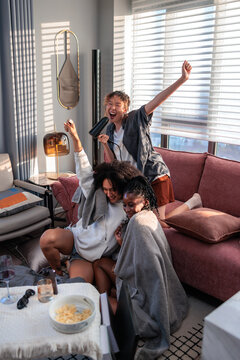 Three Friends Enjoying a Playful Singalong at Home