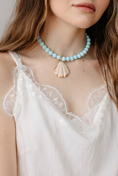 Anonymous woman in beautiful necklace with seashell