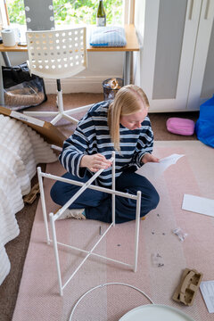Gen Z girl building furniture.