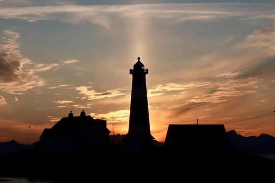 Light beam behind Lighthouse Silhouette during Sunset on Lofoten