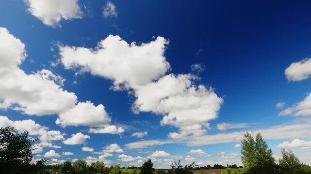 Sunny Summer Sky With Fast Moving White Clouds Above Low Horizon, Blue Sky Cloudscape Timelapse Background