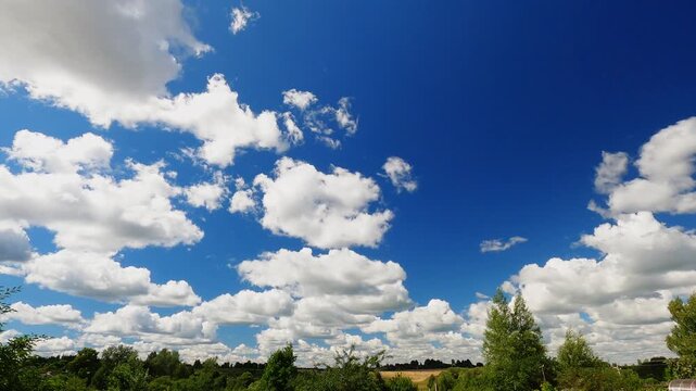 White Puffy Clouds Drifting Across Deep Blue Summer Sky With Bright Sunlight, Natural Cloudscape Timelapse