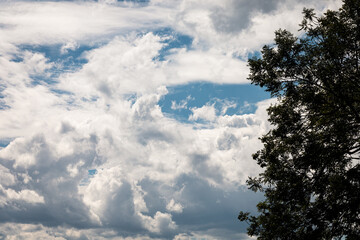 White clouds drift against a soft blue sky © Romain