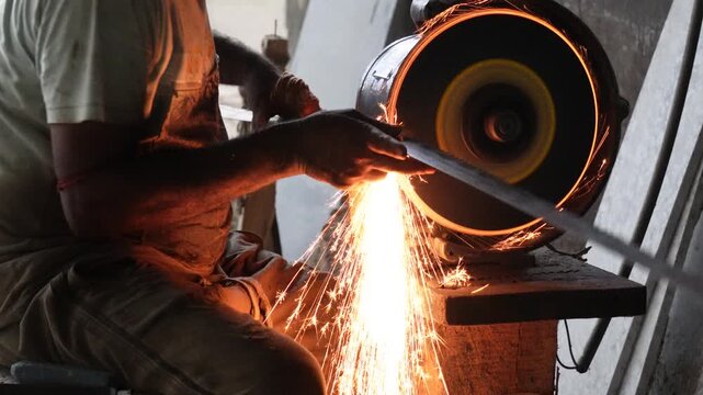 Worker sharpening metal with bright sparks