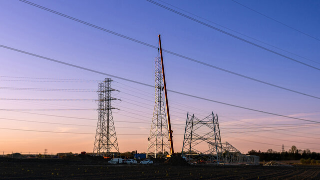 High Voltage Pylon Installation During Golden Hour