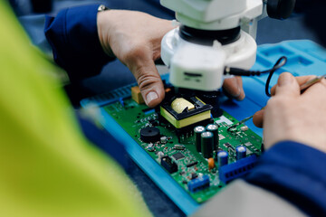 Electronics technician assembling circuit board under microscope for technology background and repair service © Parilov