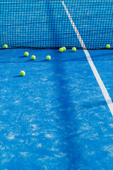 Naklejka premium Tennis balls near black net on blue padel court The Concept of sports training and athletic competition