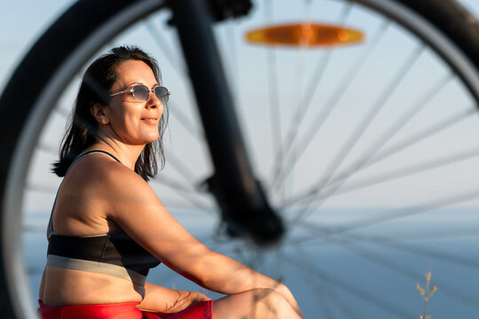 Woman bicycle summer, a smiling woman in sunglasses relaxing outdoors next to a bicycle during a sunny summer afternoon session